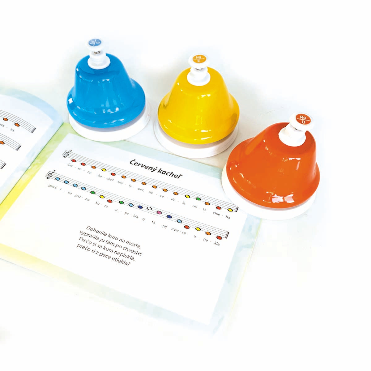 notebook with notes for music and a blue , yellow, red music desk bells